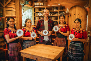 Holy Wow Cacao founder and four Mayan women holding women-made ceremonial cacao blocks in a wooden workshop