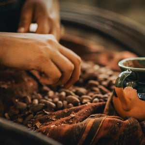 Ceramic mug on a woven surface with coffee beans